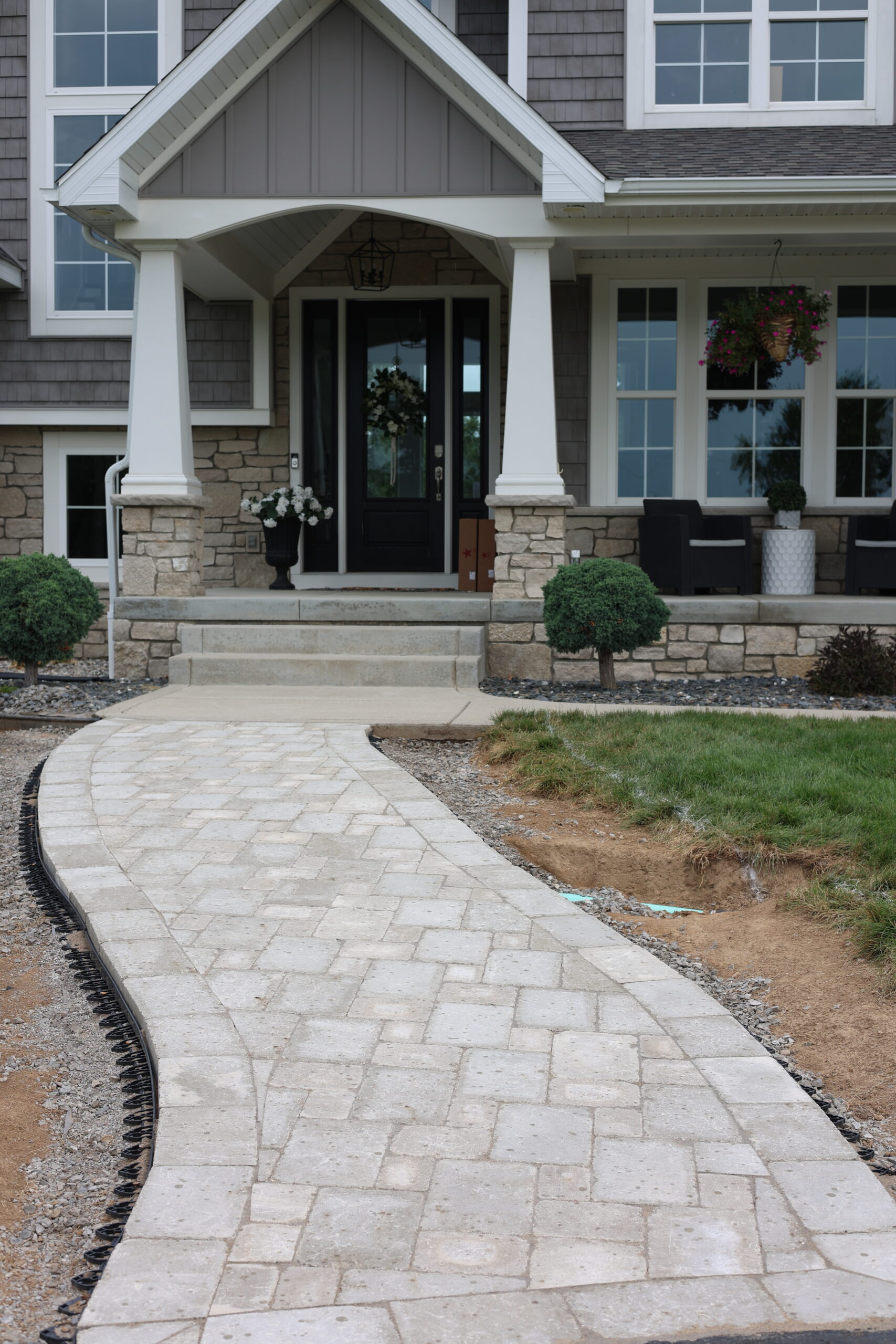 Stately home with a stone paver pathway leading to the front porch